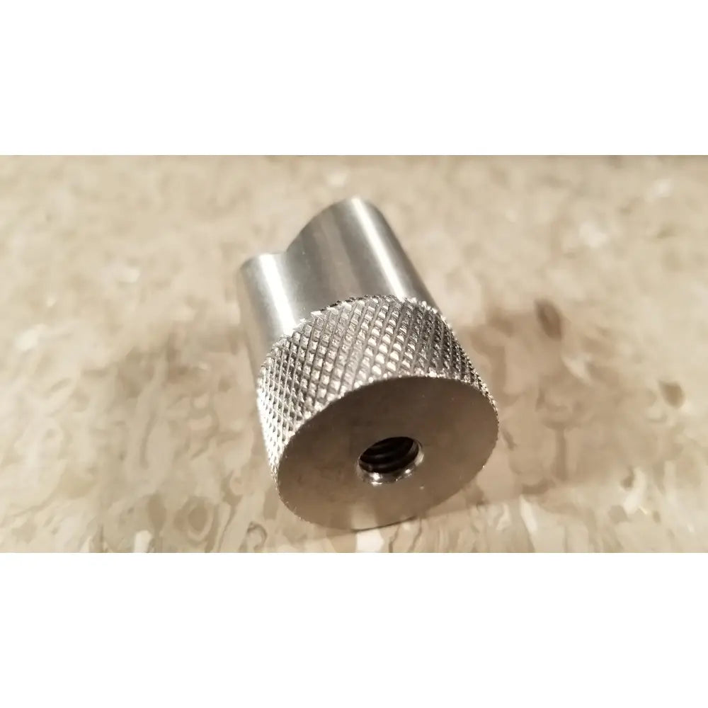 Silver metallic cylindrical adapter with knurled texture and centered threaded hole for chaltilon csd200 dynamometer reuse medical use