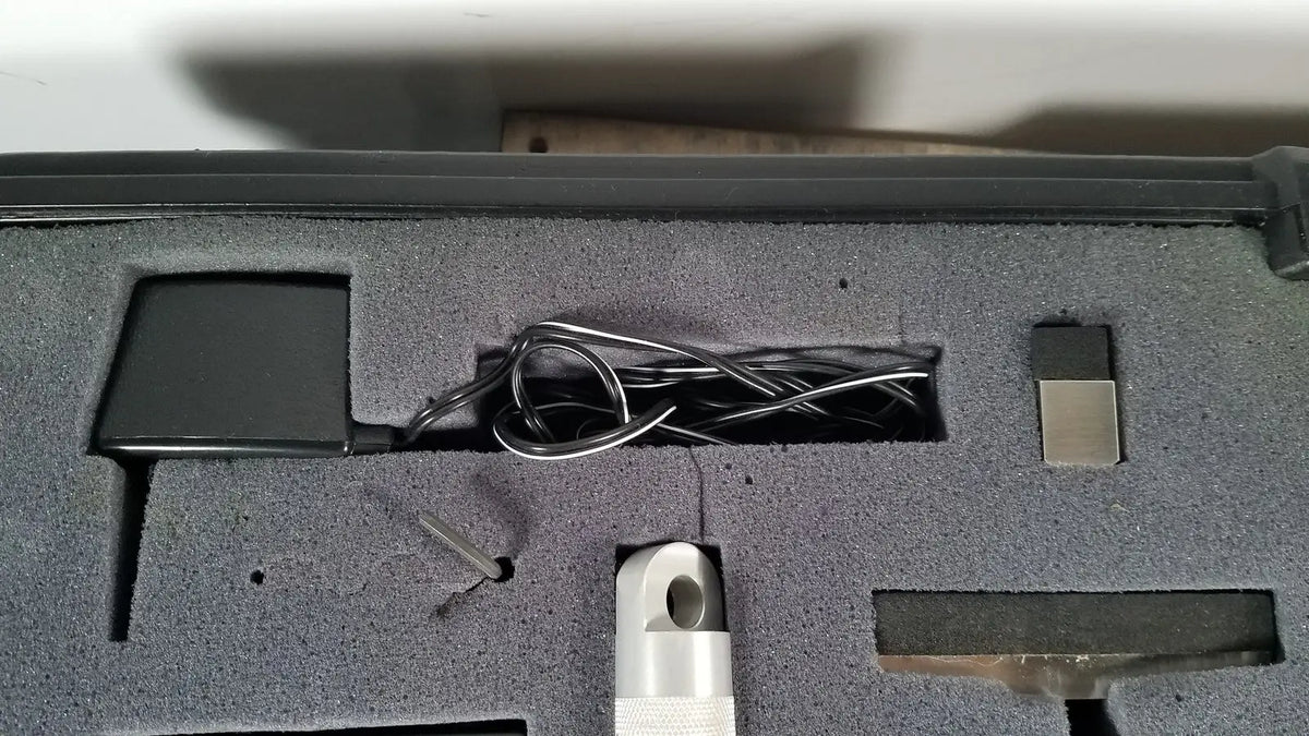 Black rectangular power adapter with coiled silver cable in gray foam for chaltilon csd200 dynamometer reuse medical kit