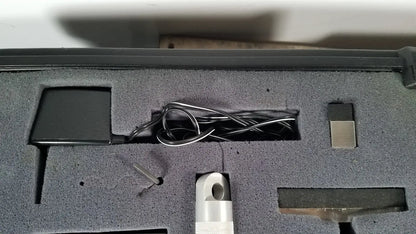 Black rectangular power adapter with coiled silver cable in gray foam for chaltilon csd200 dynamometer reuse medical kit
