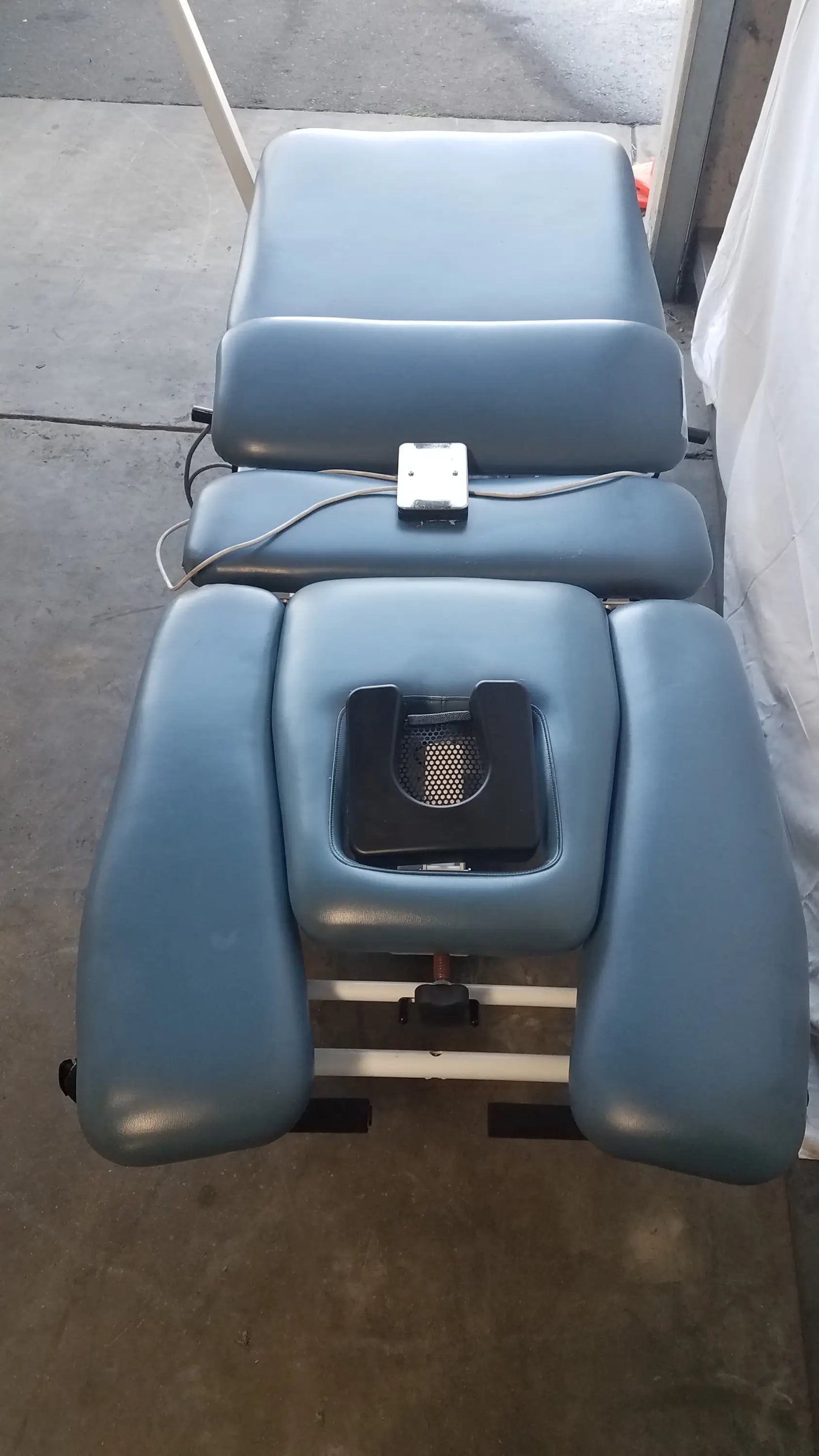 Blue padded Chattanooga TRITON DTS traction table with segmented sections and black headrest for physical therapy equipment