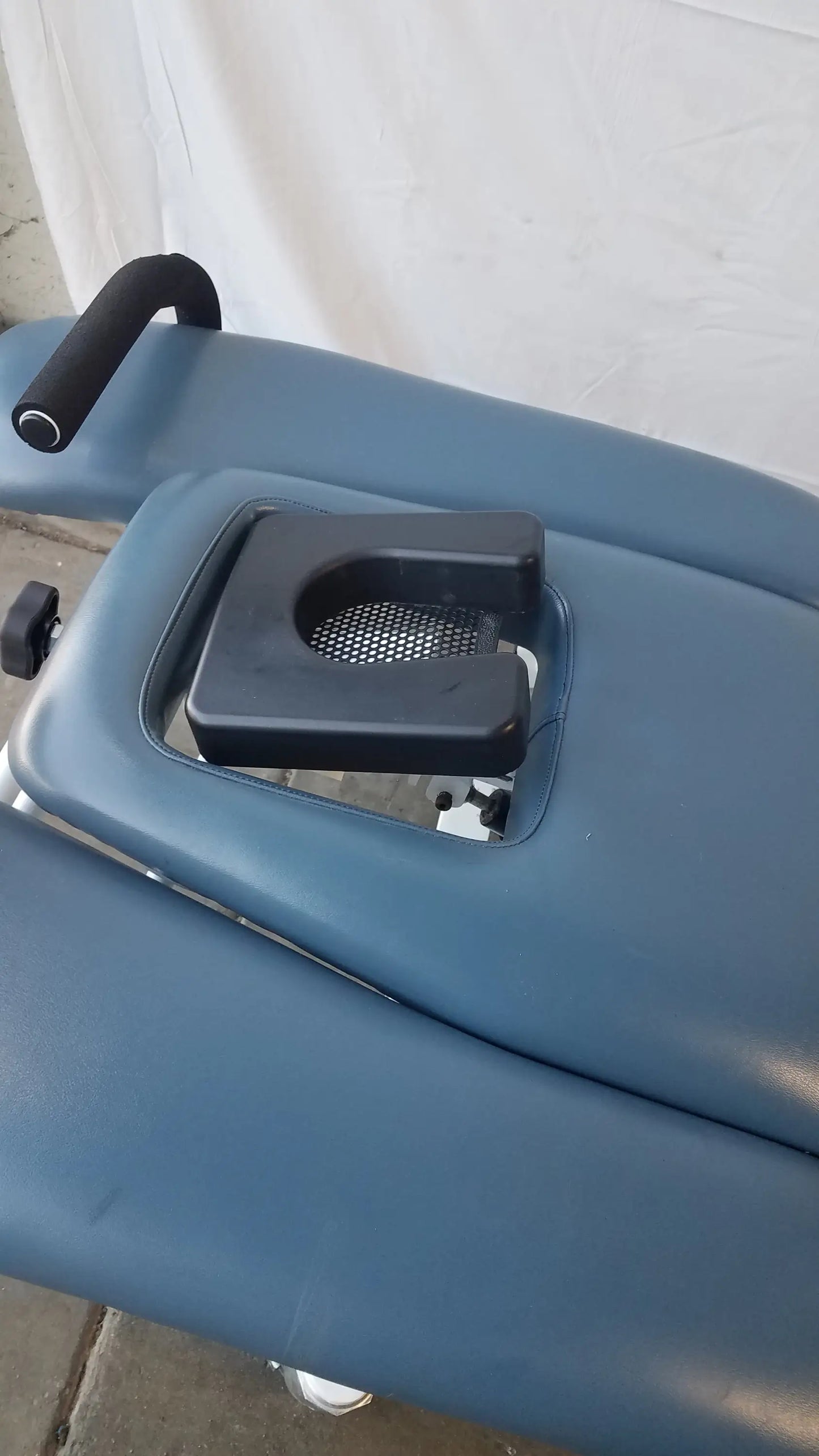 Blue padded Chattanooga TRT-600 Triton DTS traction table with black headrest and metal mesh insert for physical therapy equipment