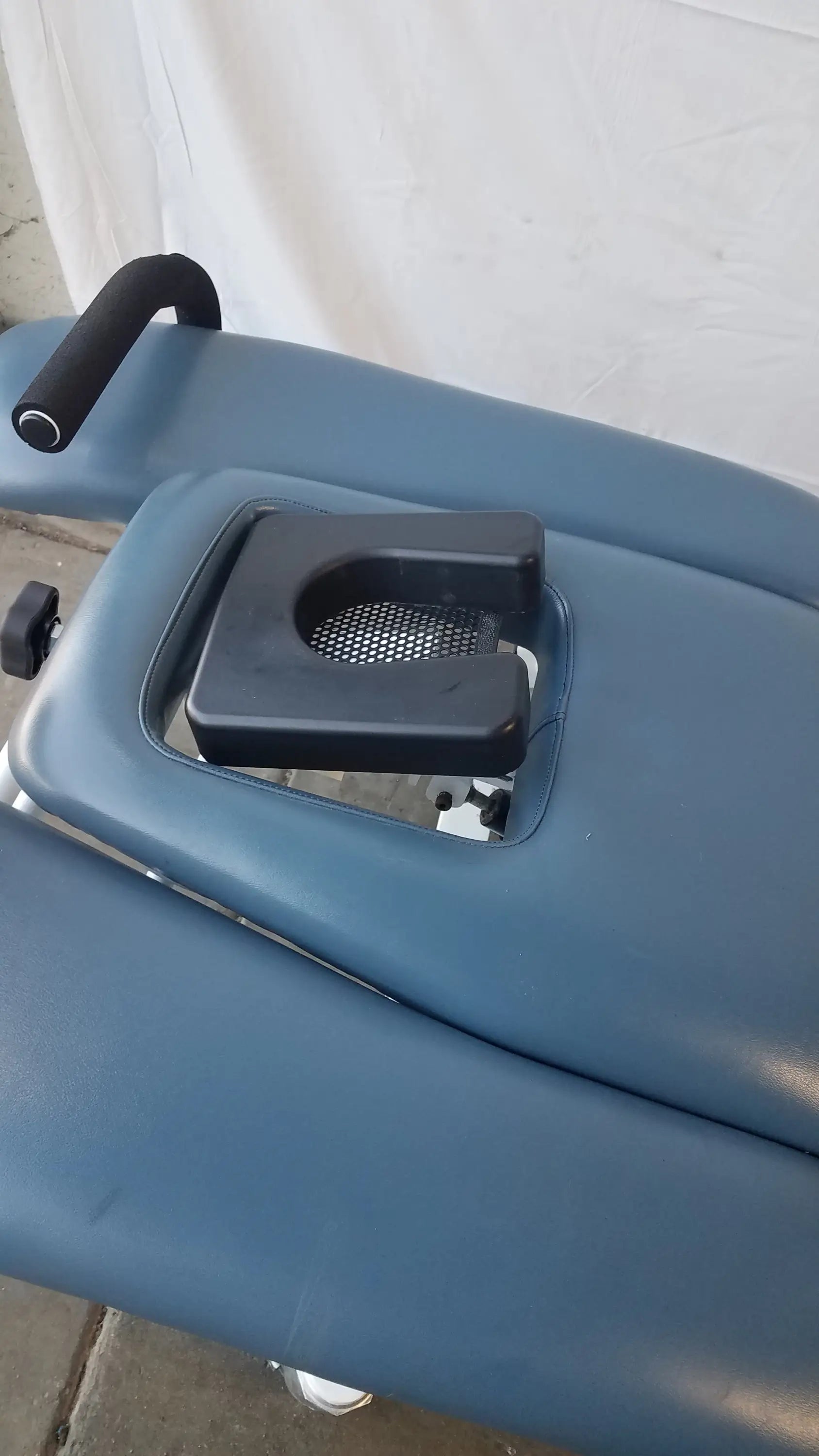 Blue padded Chattanooga TRT-600 Triton DTS traction table with black headrest and metal mesh insert for physical therapy equipment