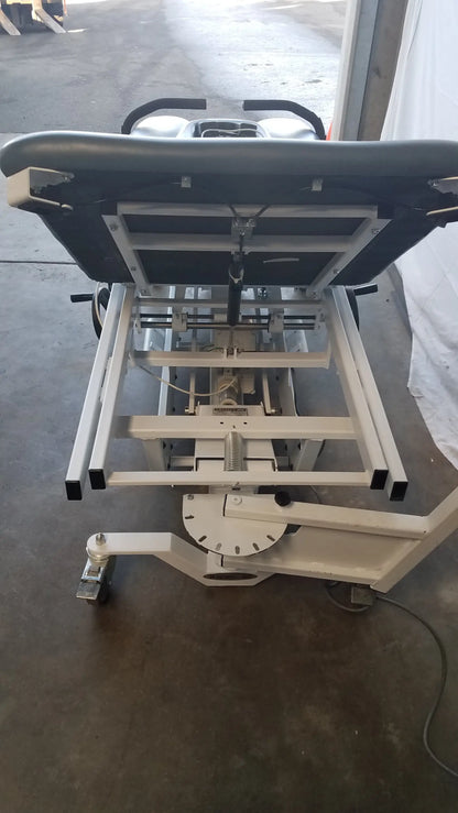 Medical-grade adjustable patient lift with black padded headrest and white metal frame for triton dts physical therapy equipment