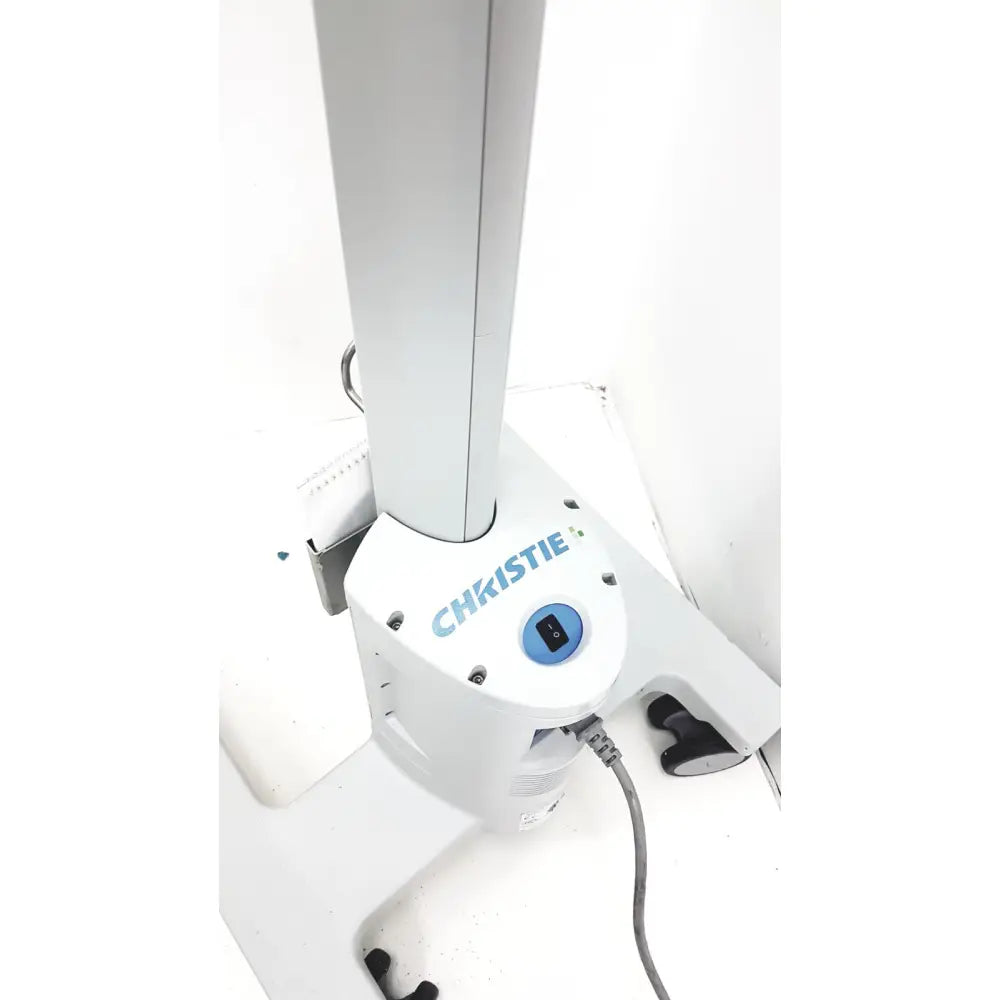 White Christie brand medical examination table base with blue power button and black foot pedal for Christie VeinViewer Vision vein visualization system