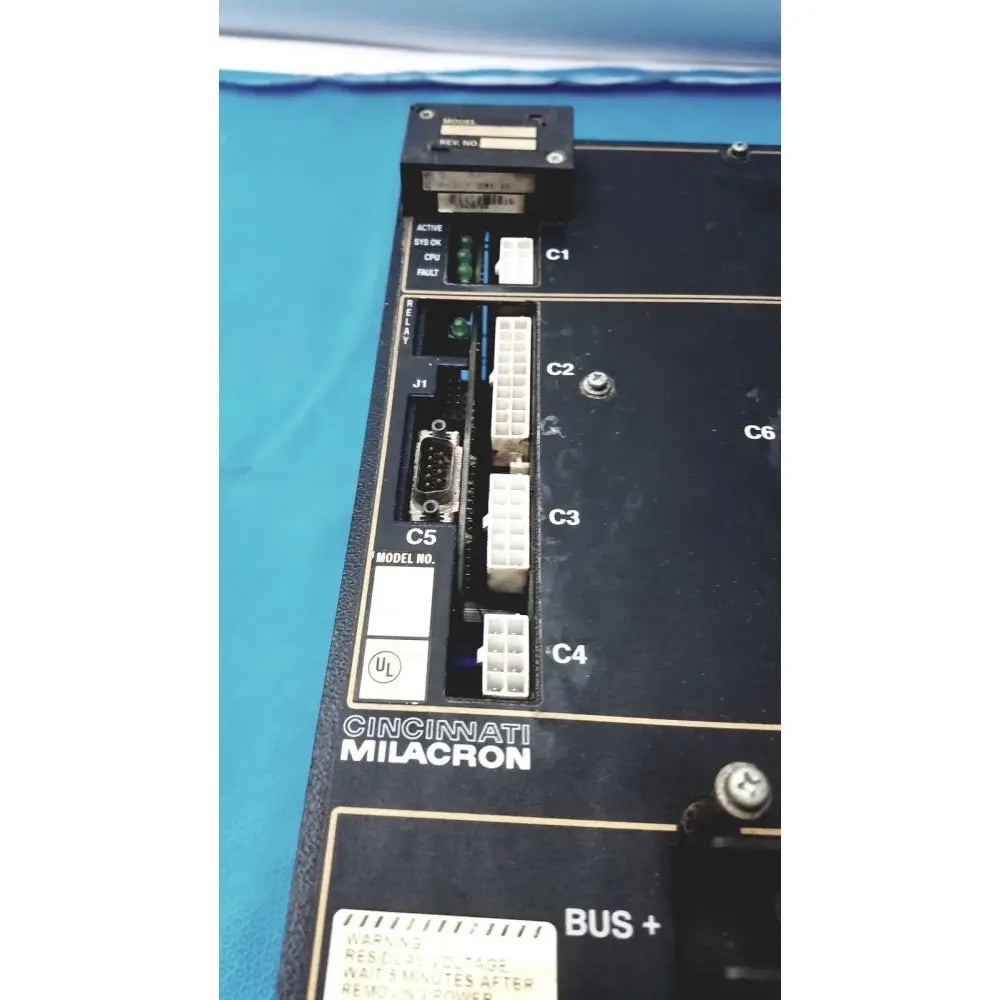 Black Cincinnati Milacron industrial control panel with white connectors and gold labeling for Milacron C5 spindle drive