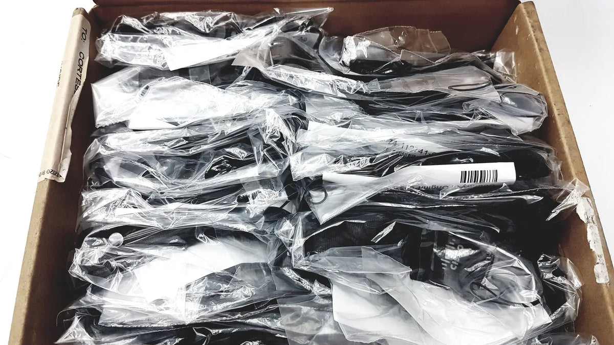 Black plastic safety goggles in clear packaging suitable for reuse medical and office desk accessories use