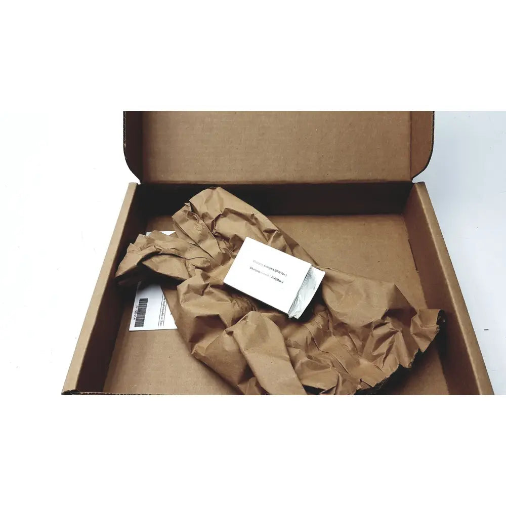 A white rectangular cisco cp-batt-7925g-ext wireless ip phone accu battery inside a brown cardboard shipping container wrapped in paper