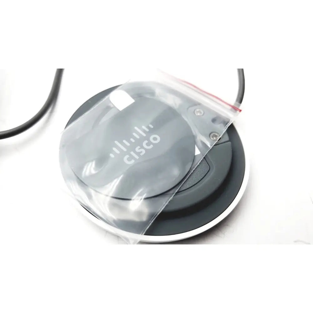 Gray circular cisco cs-mic-table-e table microphone with euroblock plug partially covered in clear plastic bag