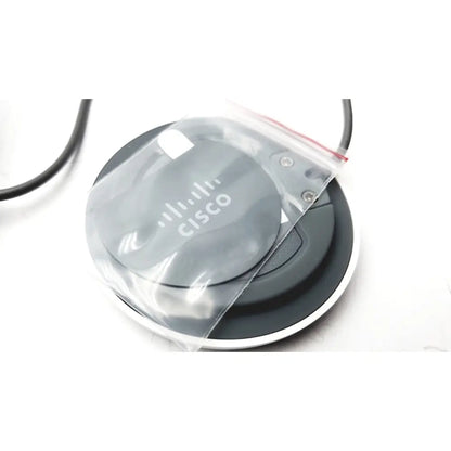 Gray circular cisco cs-mic-table-e table microphone with euroblock plug partially covered in clear plastic bag