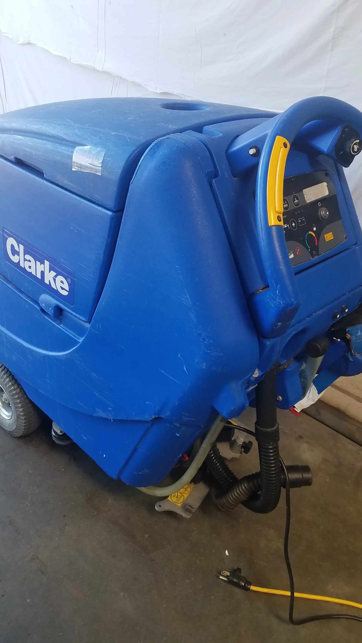 Clarke focus ii boost floor scrubber with blue body yellow control panel and black hoses industrial floor cleaning machine