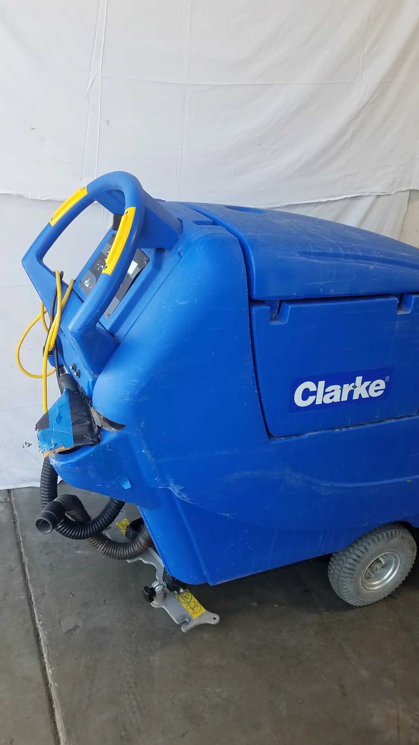 Blue Clarke focus ii boost floor scrubber with yellow handle accents and black hoses for industrial floor cleaning