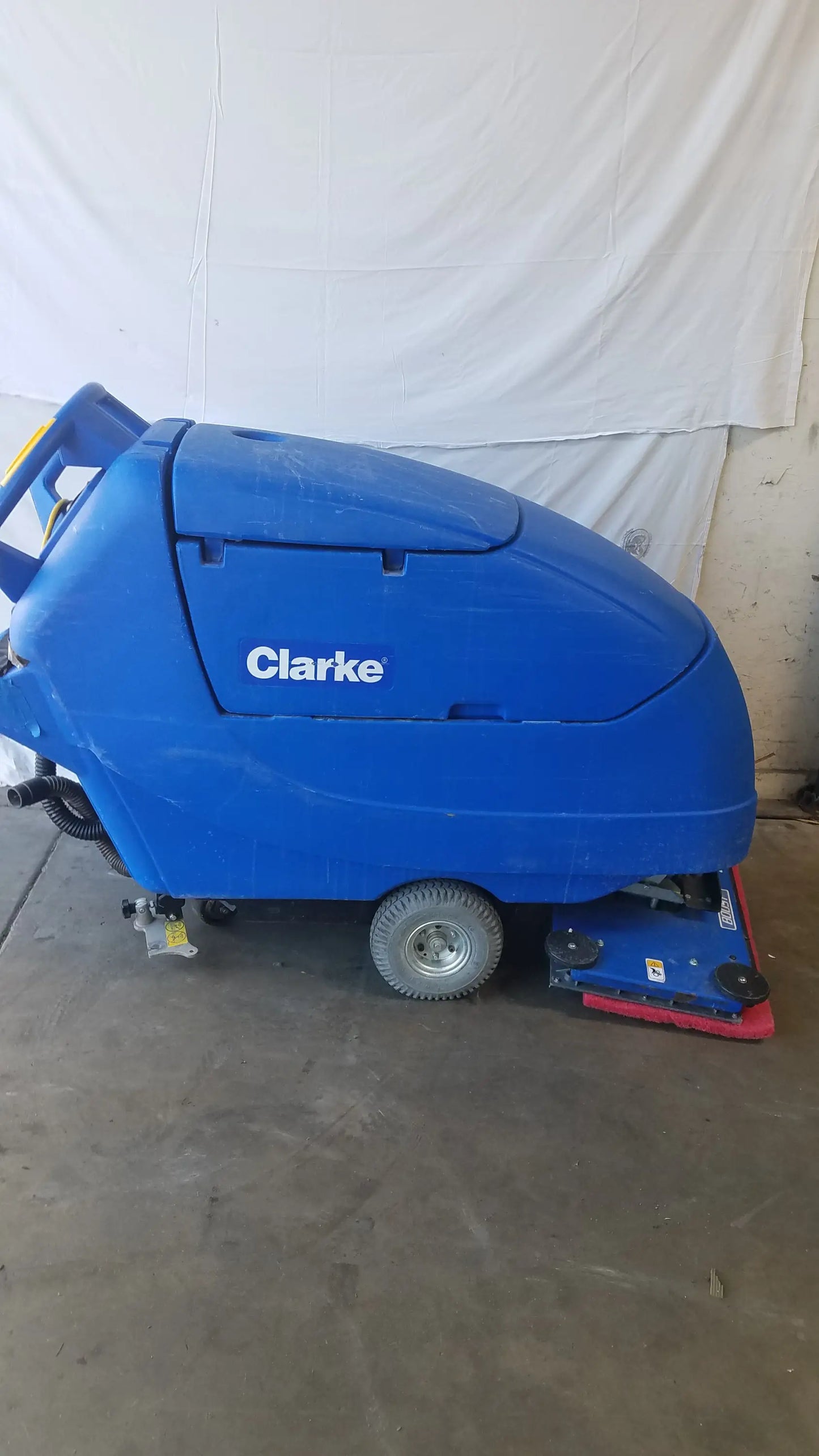 Blue Clarke Focus II Boost floor scrubber with a red cleaning head and black wheels for efficient floor cleaning