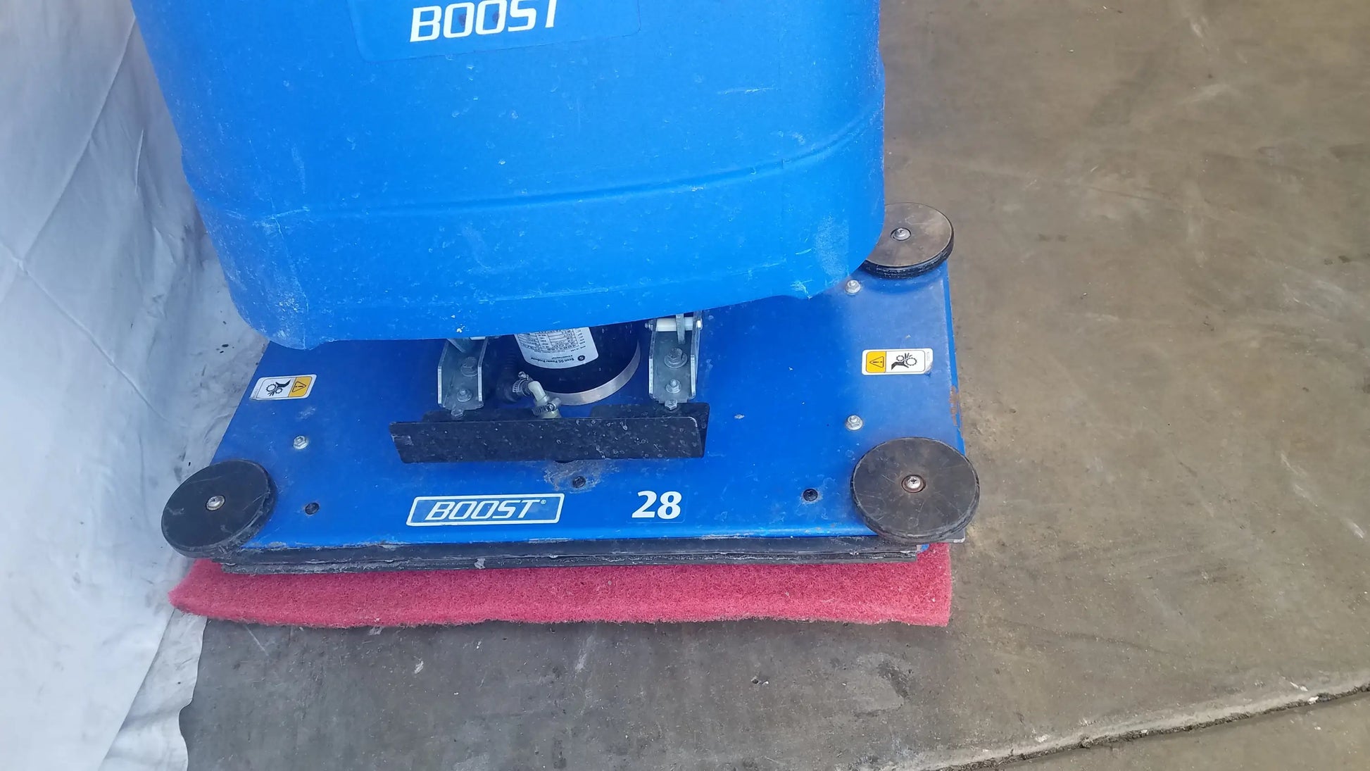 Clarke Focus II Boost 28 floor scrubber with blue body, red scrubbing pad, and black wheels for efficient floor cleaning