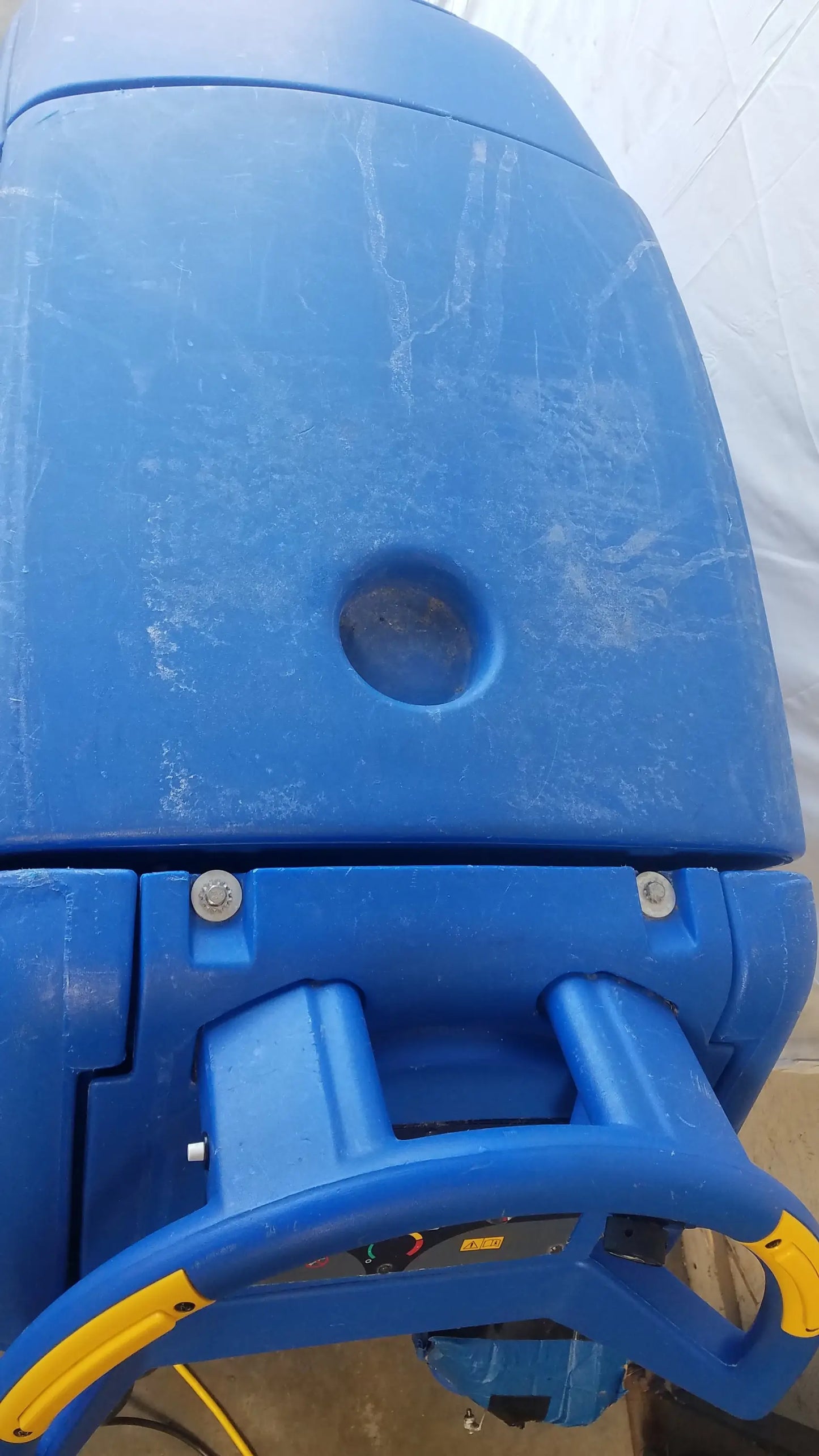 Blue plastic Clarke Focus II Boost floor scrubber with yellow accents and circular top opening for industrial cleaning