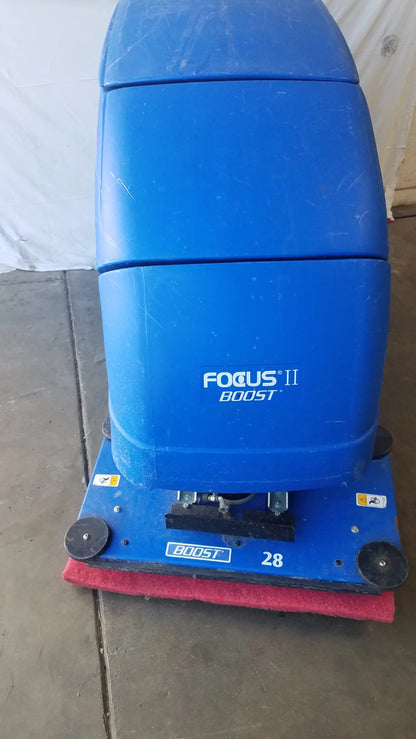 Clarke focus ii boost floor scrubber in blue plastic with red scrubbing pad and black wheels for floor cleaning