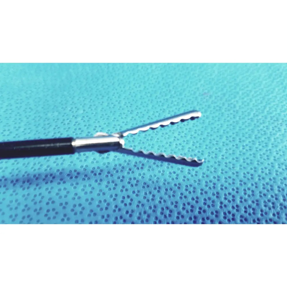 Silver claw gasper surgical forceps with serrated jaws and black handle on blue textured surface for reuse medical laparoscopic instruments
