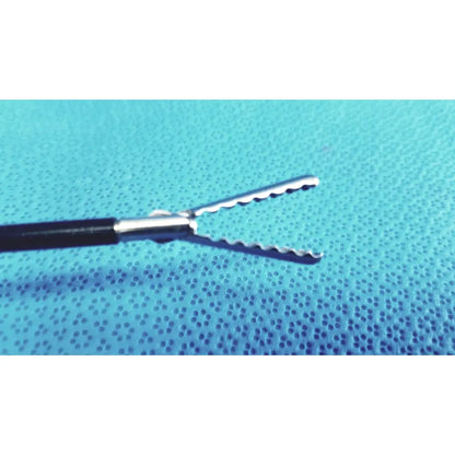 Silver claw gasper surgical forceps with serrated jaws and black handle on blue textured surface for reuse medical laparoscopic instruments