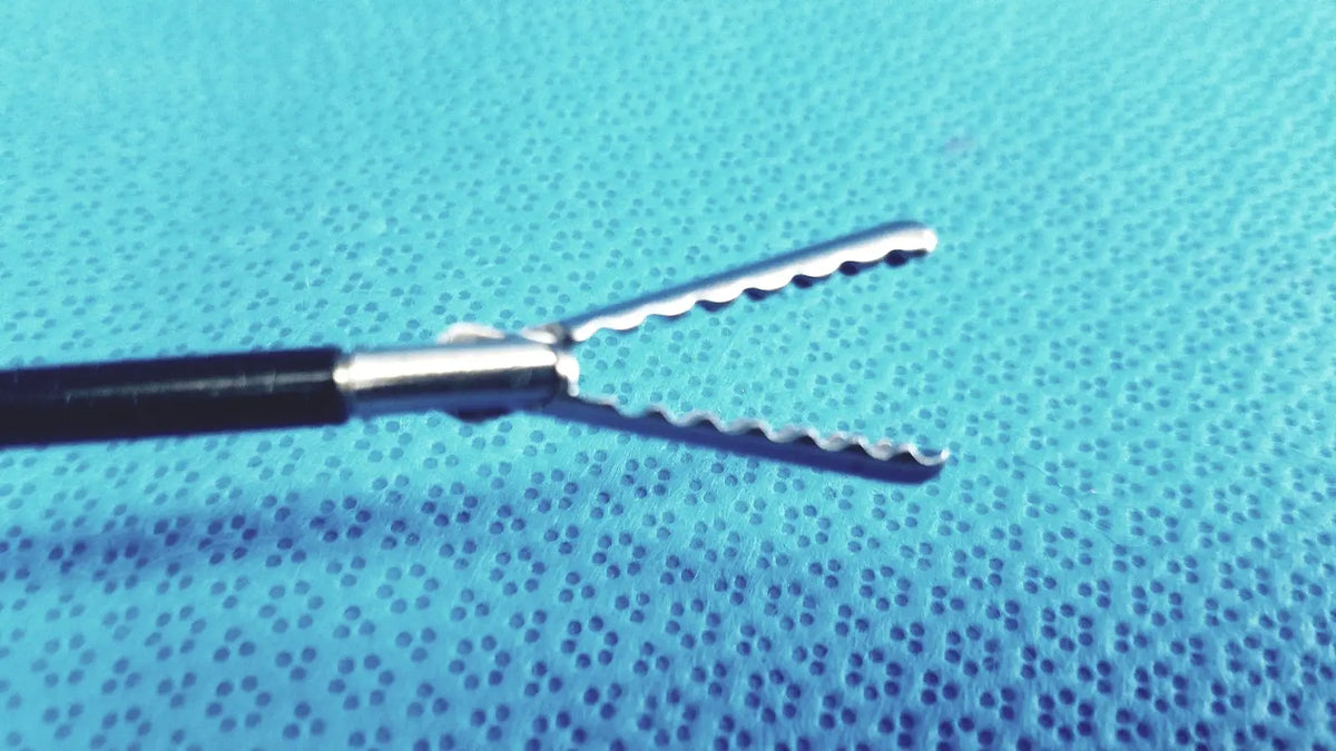 Silver claw gasper surgical forceps with serrated jaws and black handle on blue textured surface for reuse medical laparoscopic instruments