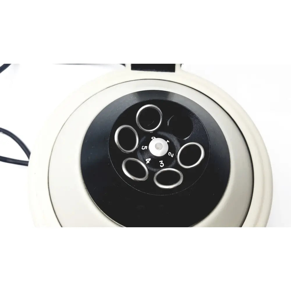 Cream vintage-style rotary telephone with black dial and silver number rings shown with clay adams roche model analytical centrifuge