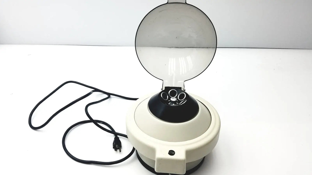 Cream-colored clay adams roche model 0171 analytical centrifuge with transparent dome lid and black rotor chamber