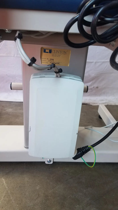 White rectangular electrical box with black cables mounted under the back side of clinton 6341 power series blood drawing chair
