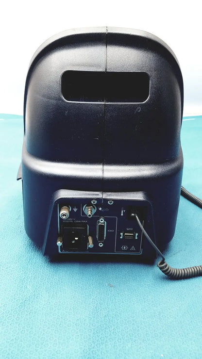 Black plastic audio mixer with multiple ports and coiled cable at the back of colin press-mate prodigy ii 2240 patient monitor