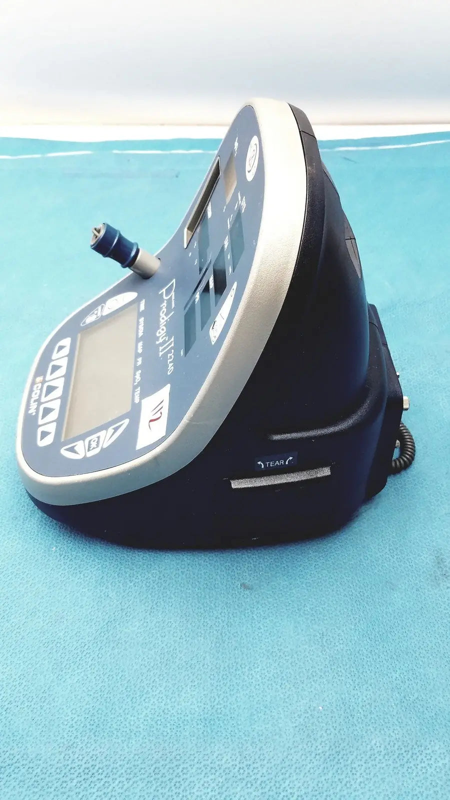 Blue and gray handheld colin press-mate prodigy ii 2240 patient monitor with digital display control buttons and cuff attachment