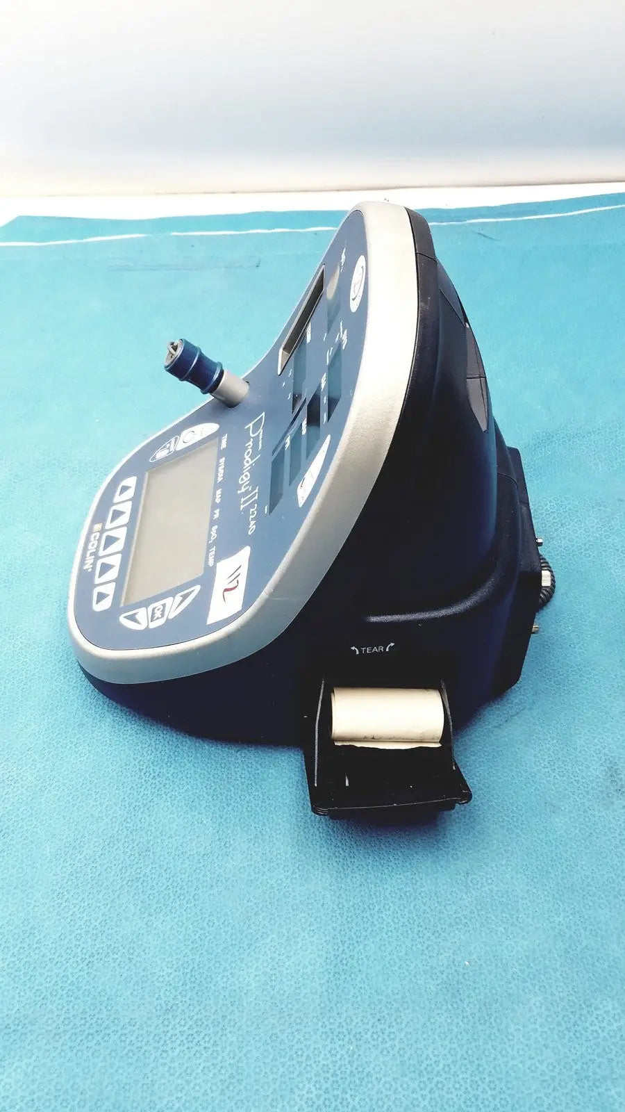 Blue and silver handheld colin press-mate prodigy ii 2240 patient monitor with digital display, control buttons, and cuff attached