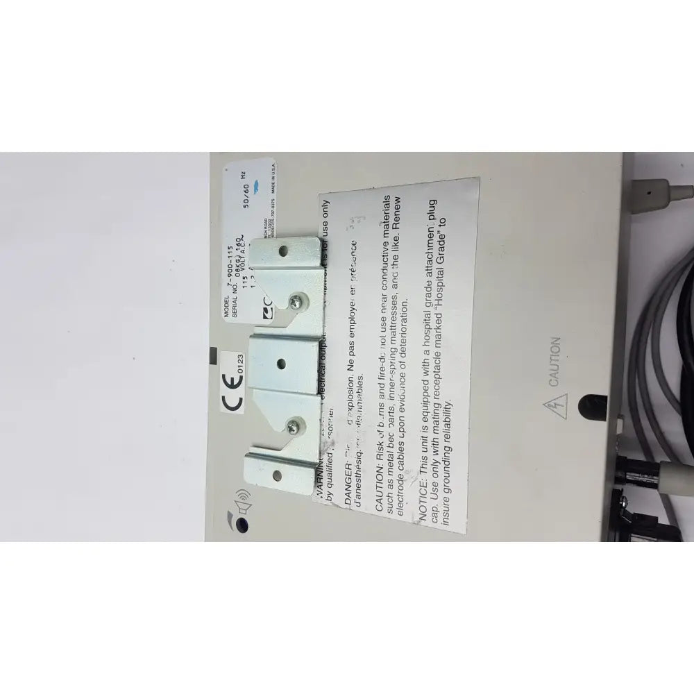 White plastic electrical outlet cover with silver screws and ce mark label for reuse medical equipment conmed 2000 unit