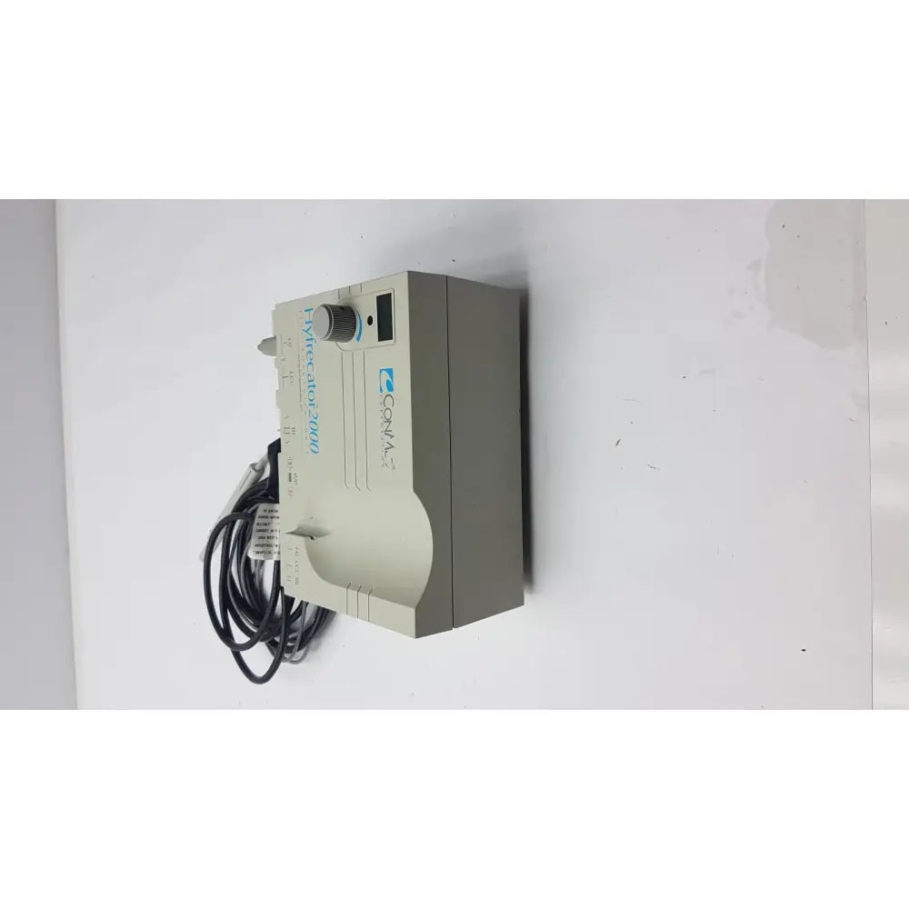 Beige rectangular conmed 2000 unit humidifier control with gray knob and black power cord for reuse medical equipment