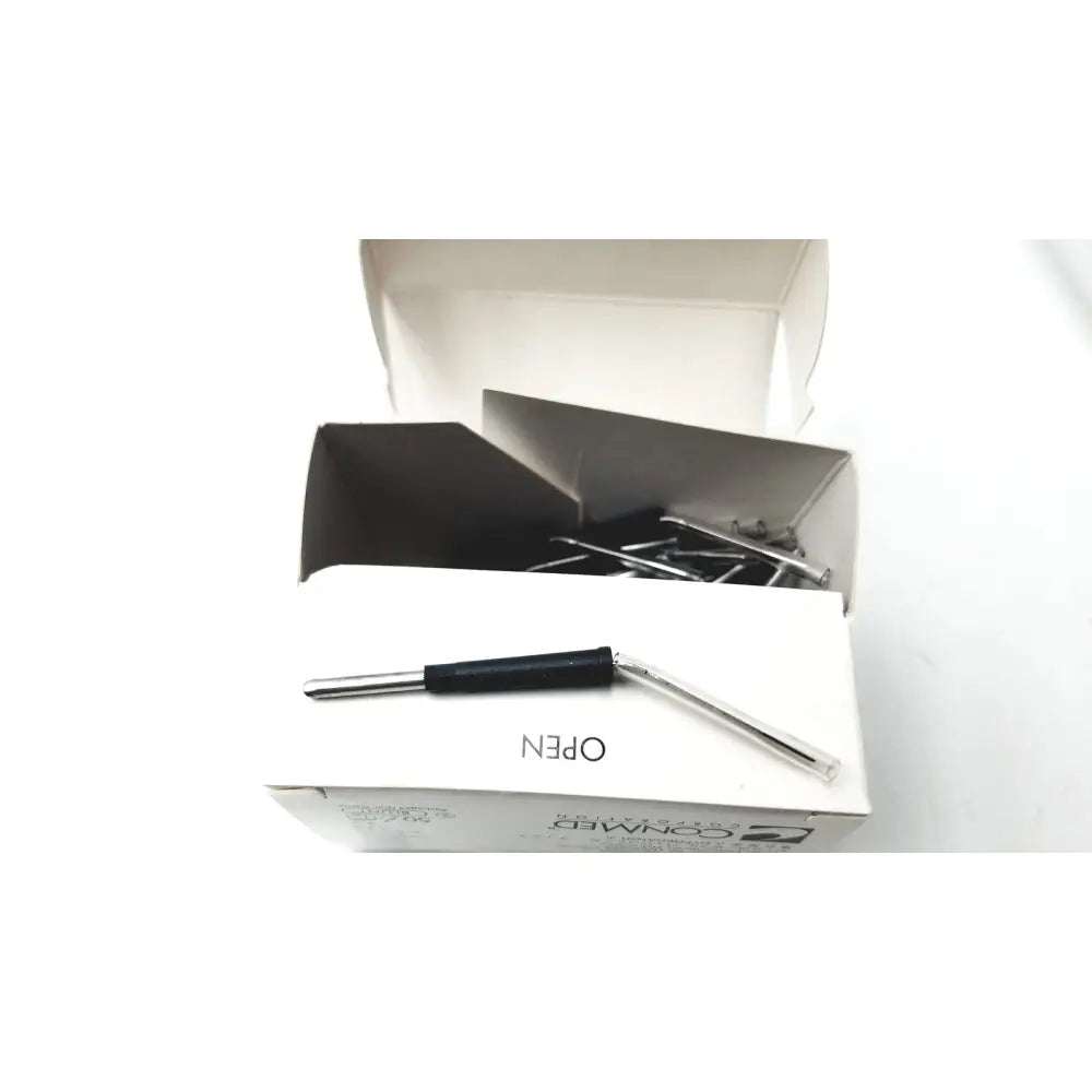 Silver paperclip opener with black handle resting on white packaging of conmed hyfrecator reuse medical electrosurgical system accessories