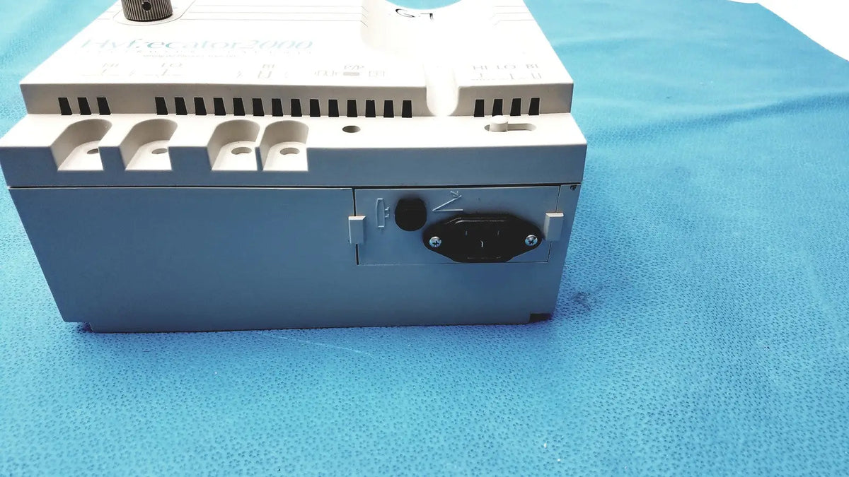 Gray and white industrial power supply unit with black ac input plug on the back side of conmed hyfrecator high frequency equipment