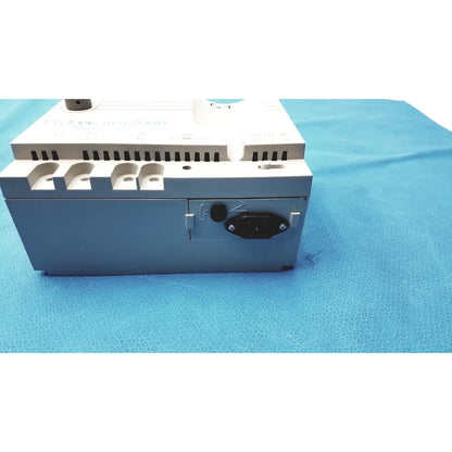 Gray and white industrial power supply unit with black ac input plug on the back side of conmed hyfrecator high frequency equipment