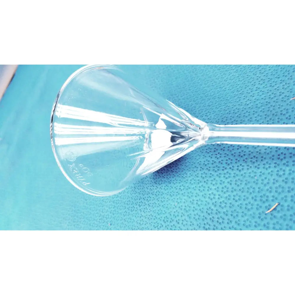 Clear glass corning pyrex fluted funnel with a long stem and etched pirelli branding for lab use