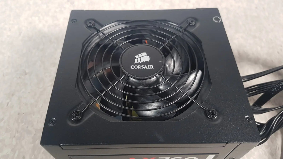 Black corsair ax760 760w fully modular power supply with circular fan and protective grille for efficient cooling