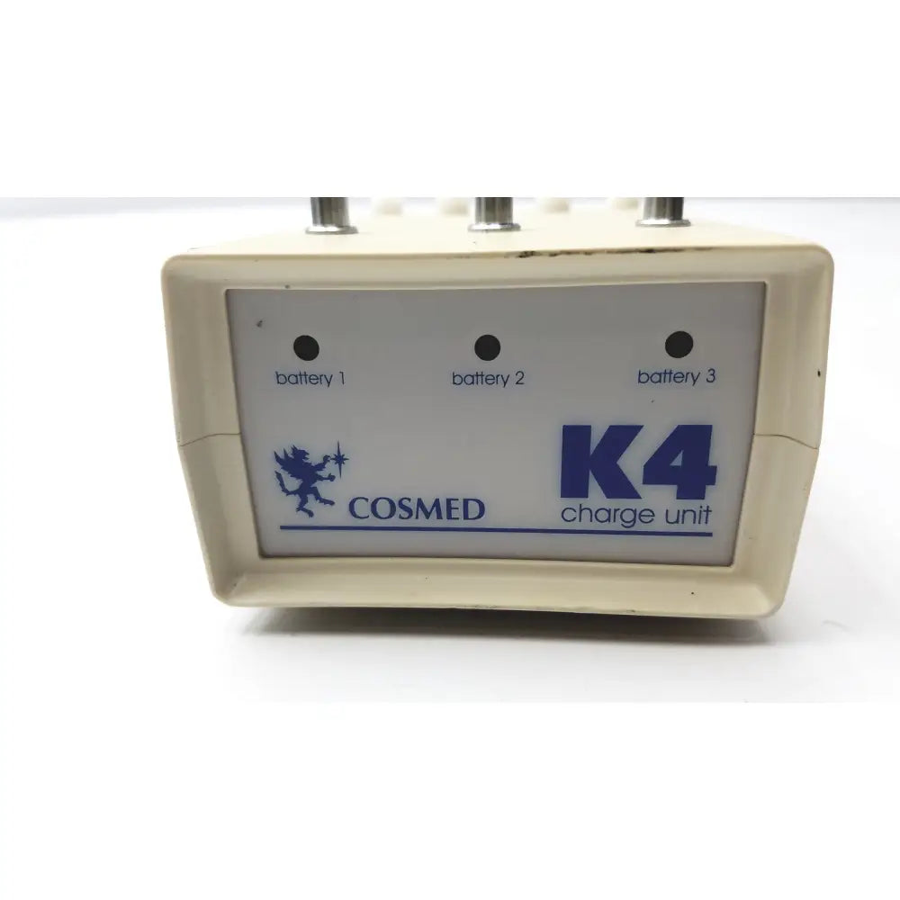 Cream-colored plastic Cosmed K4 B2 metabolic charge unit with blue branding and three battery indicator lights for reuse medical purposes