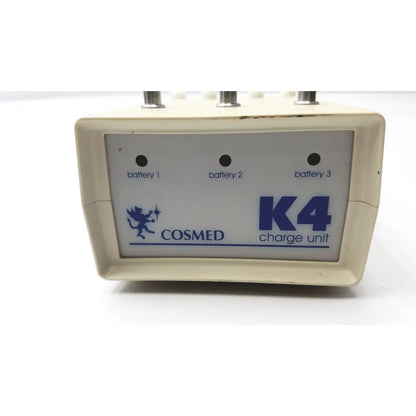 Cream-colored plastic Cosmed K4 B2 metabolic charge unit with blue branding and three battery indicator lights for reuse medical purposes