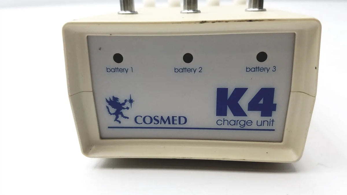 Cream-colored plastic Cosmed K4 B2 metabolic charge unit with blue branding and three battery indicator lights for reuse medical purposes