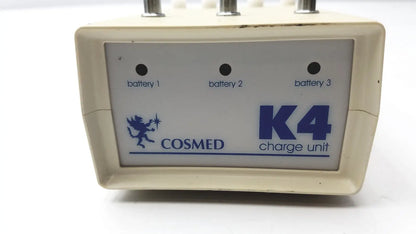 Cream-colored plastic Cosmed K4 B2 metabolic charge unit with blue branding and three battery indicator lights for reuse medical purposes