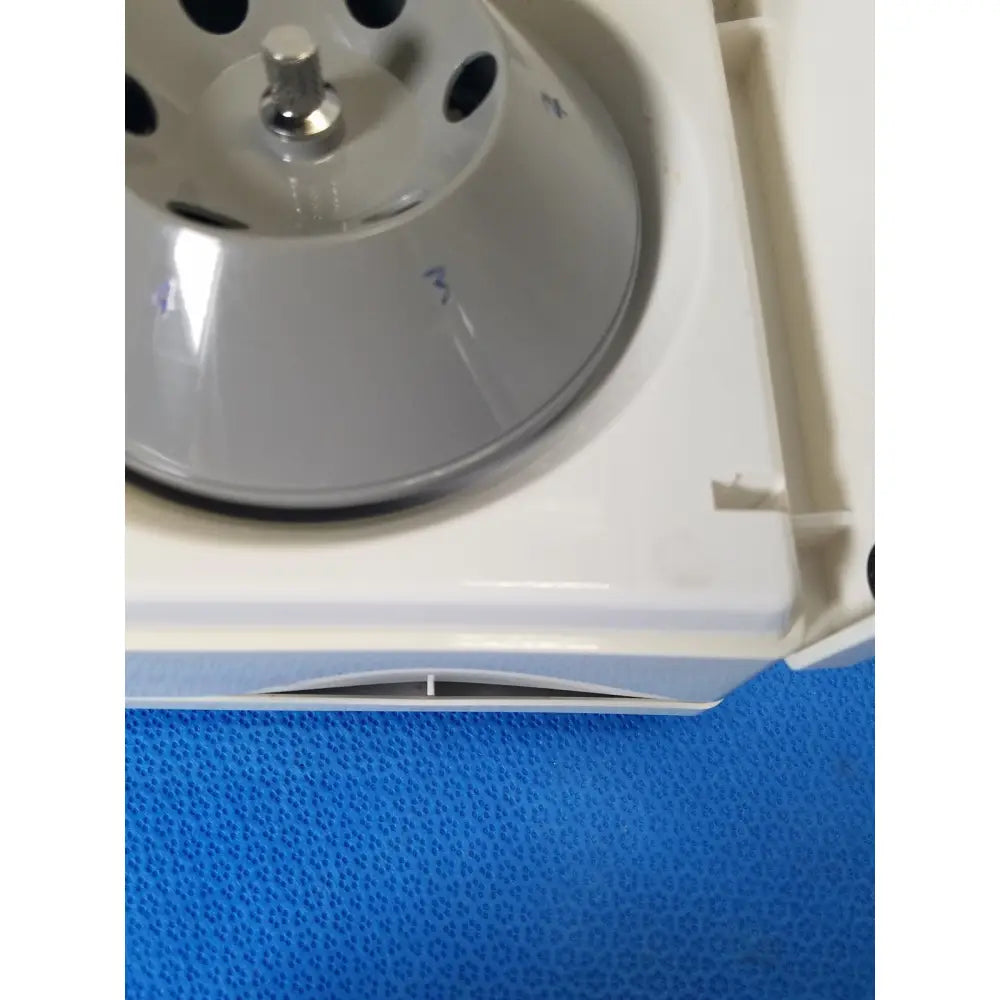 Silver fixed position angled rotor with central metallic shaft and circular holes in white casing for costar model 10 mini centrifuge