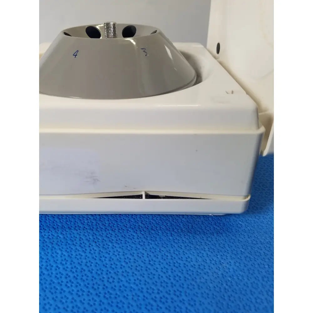 Gray plastic fixed position angled rotor with metallic spindle on white base of costar model 10 mini centrifuge