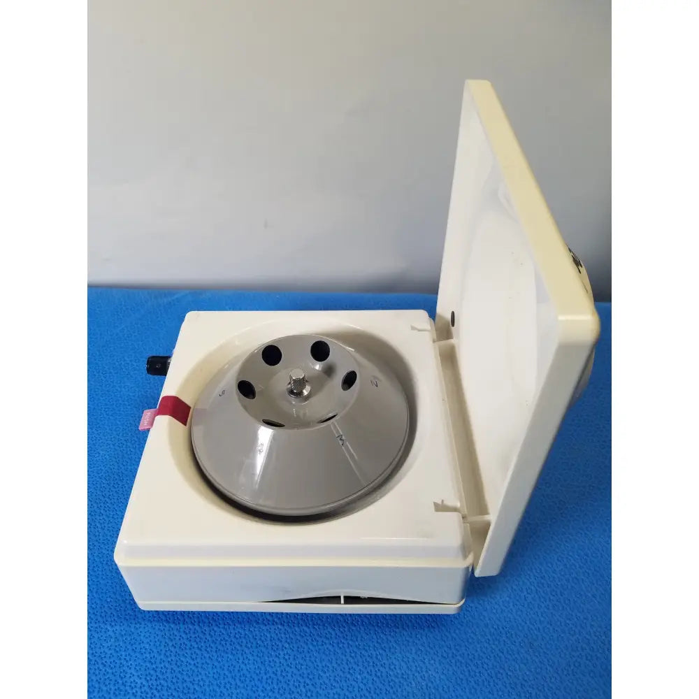 White plastic costar model 10 mini centrifuge with silver fixed position angled metallic rotor and multiple circular slots