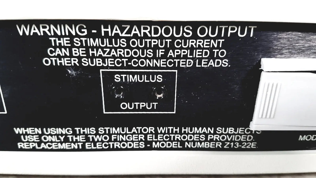 Black plastic output panel of coulbourn z13-22 stimulator with white text and two circular stimulus output ports