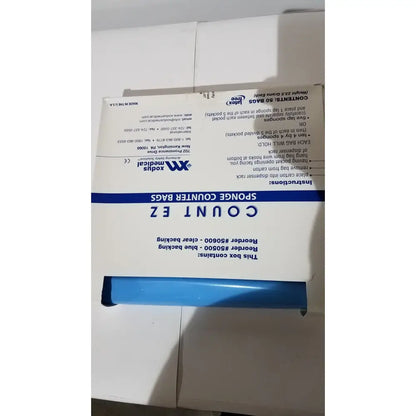 The box contains blue and clear plastic count ez sponge surgical count bags sterile and disposable