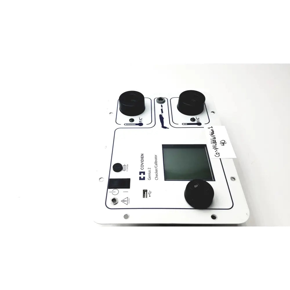White rectangular covidien genius 2 checker calibrator with black knobs and central digital screen for test meters