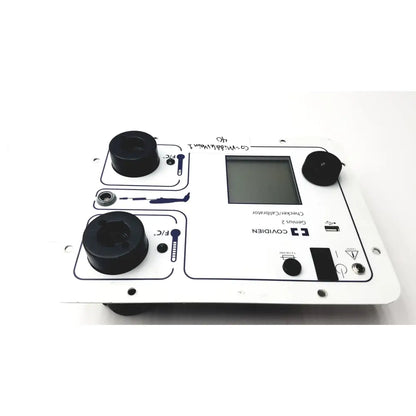 White plastic covidien genius 2 checker calibrator with black circular components and central digital display for test meters