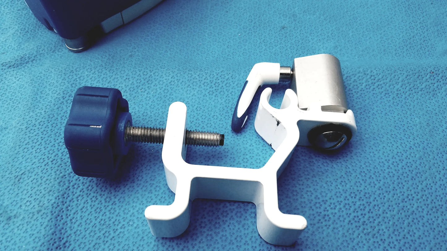 White plastic surgical clamp with blue knob and metallic screw on kangaroo joey covidien flush pump pole clamp