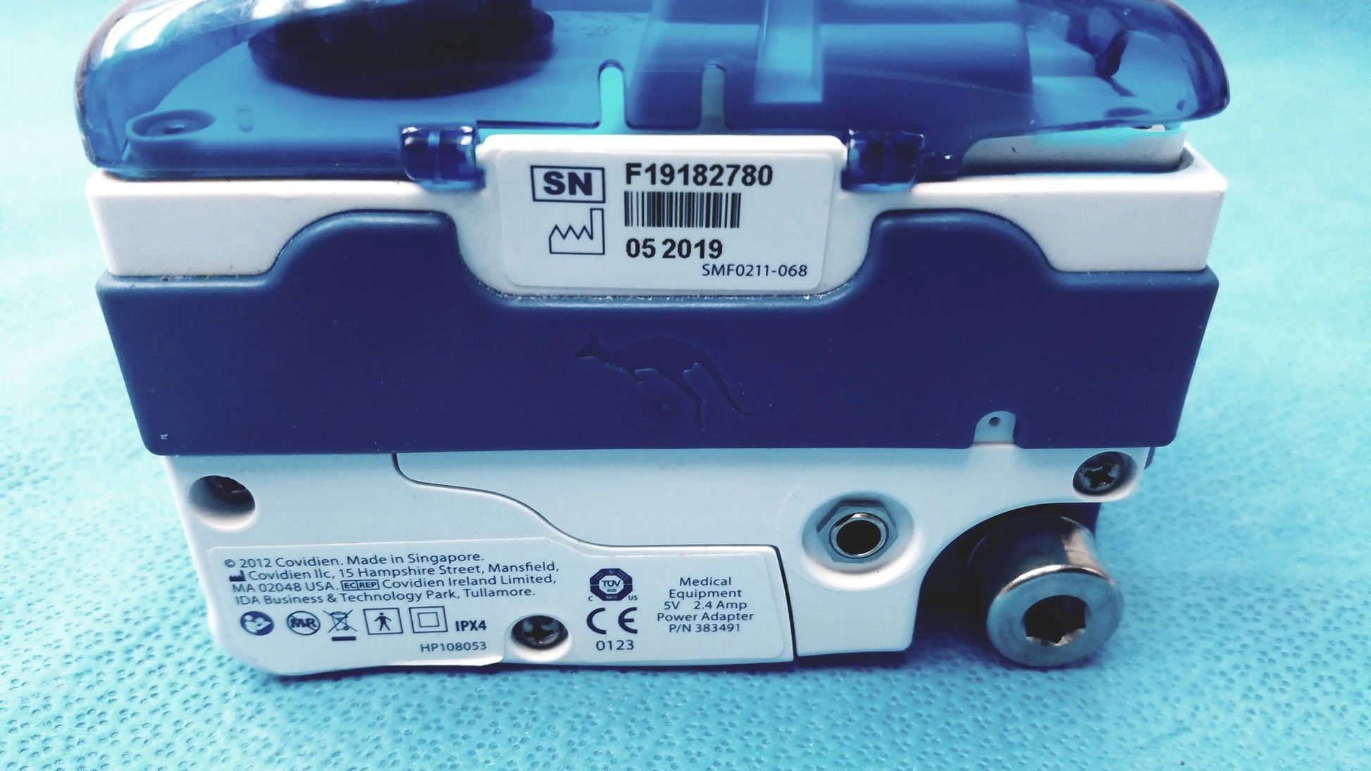 Blue and white covidien kangaroo joey enteral feed and flush pump with transparent blue top cover and pole clamp