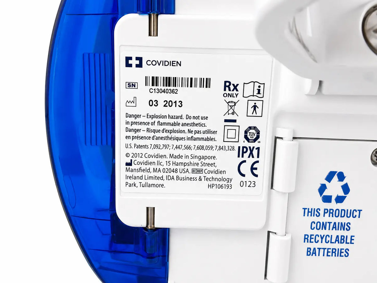White plastic covidien nutrition feeding pump with blue casing label showing regulatory and recycling info