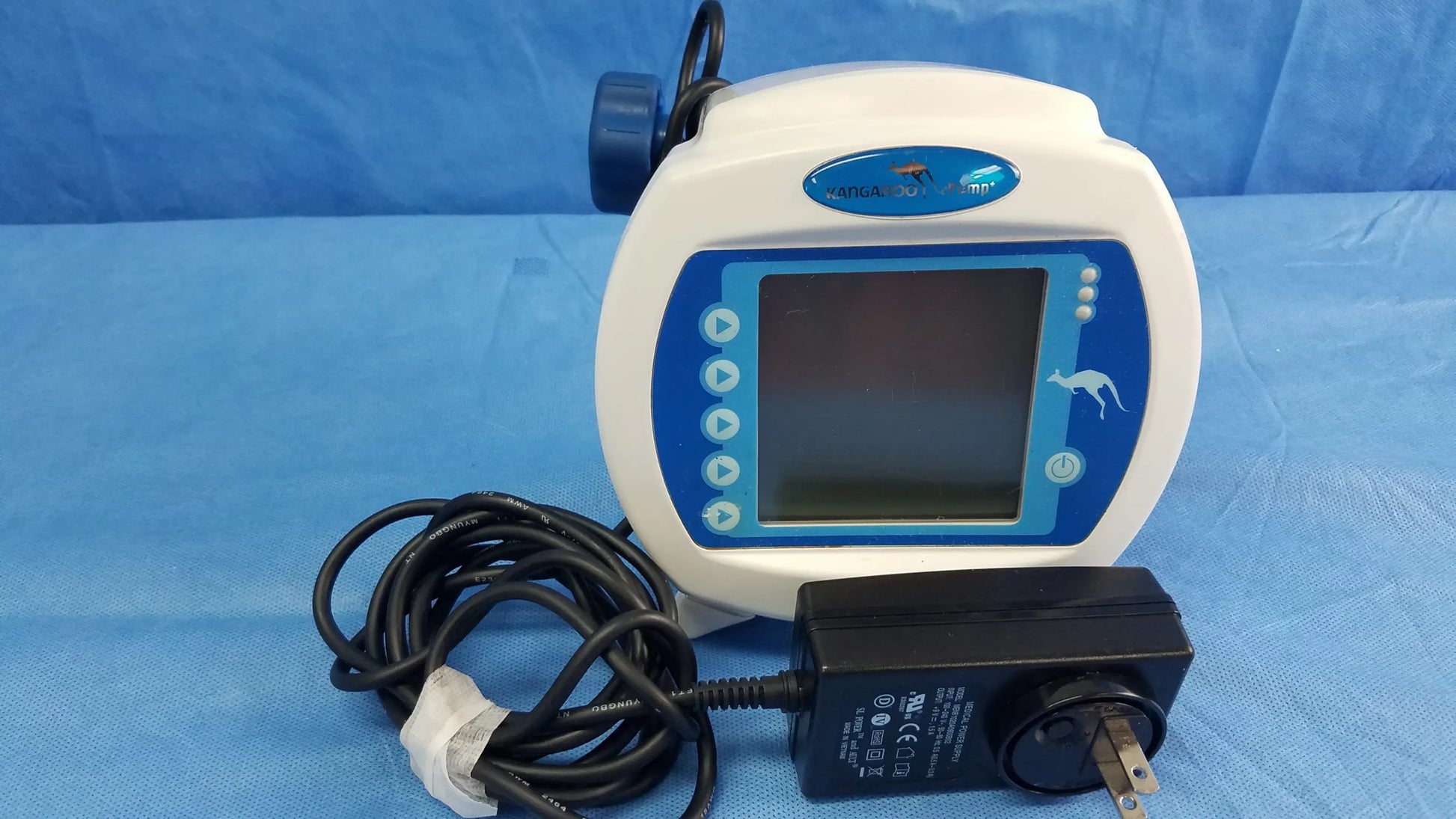 White and blue Covidien kangaroo Joey nutrition feeding pump with digital display control buttons and power adapter